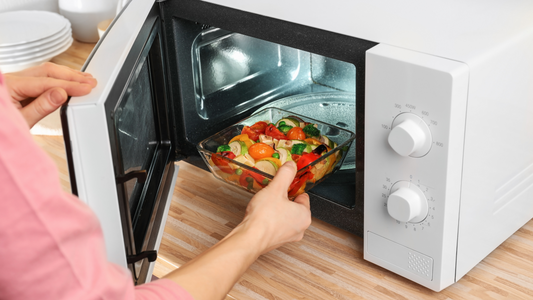 Bowl of Steamed Vegetables Next to Microwave